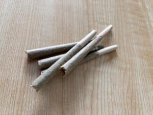 A couple of grams of Rolled marijuanna flower joints on top of a wooden table, pre rolls